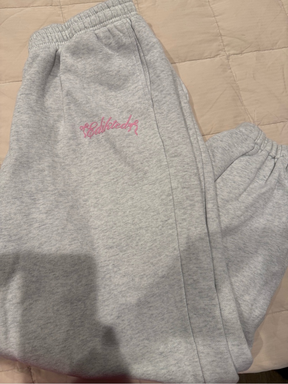 Edikted Light Gray Sweatpants with Pink Script Logo and bow.